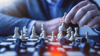 Man playing chess large pieces - a red light in the middle free wallpaper