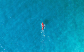Red kayak ocean aurora night - dave allsop free wallpaper