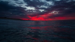 Red blue sky ocean island - a lighthouse in the distance free wallpaper