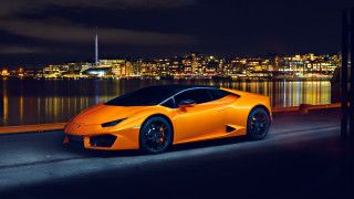 Bright orange sports car night 2 - the side of a road near a body of water free wallpaper