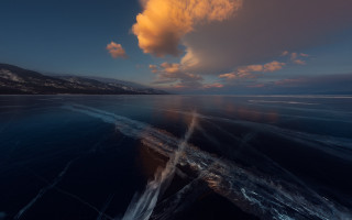 Boat mountains water sunset cloudy - a body of water under a cloudy sky free wallpaper
