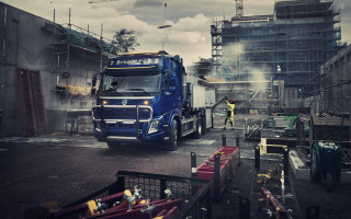 Large truck parking lot construction - a crane in the background free wallpaper