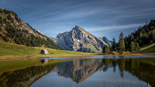 Mountain lake hut field forest - a grassy field in the foreground free wallpaper