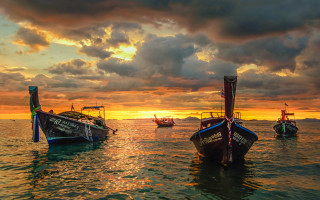 Boats water lake sunset clouds - water under a cloudy sky free wallpaper