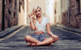 Woman sitting beach blonde denim - her hand behind her head free wallpaper