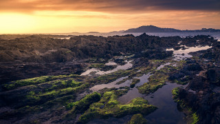 Rocky shore sunset island ocean - a small island in the distance free wallpaper