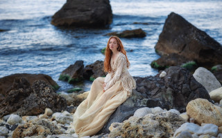 Woman sitting rock ocean smile - a rock near the ocean free wallpaper