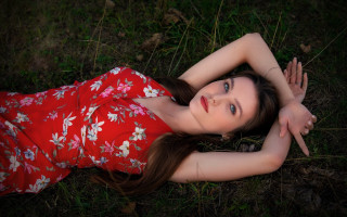 Red dress woman lying in - the grass free wallpaper