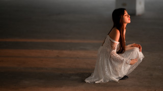 Gothic woman white dress sitting - the ground in the dark free wallpaper