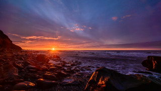 Sunset rocky beach water shore - a large body of water free wallpaper