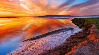 Sunset water rocky shore grassy 2 - a rocky shore free wallpaper