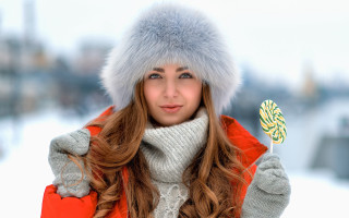 Winter coat woman holding candy - her hand and a hat free wallpaper
