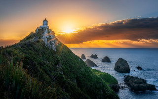 Lighthouse hill sunset ocean grassy - a picture free wallpaper