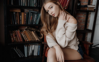 Woman sitting library book shelf - a chair in front free wallpaper