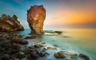 Beach sunset rock formation cloudy - the water near a beach free wallpaper