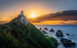 Lighthouse hill sunset ocean rocks - a lighthouse free wallpaper