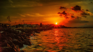 Sunset cityscape clouds water reflection - a sunset over a body of water free wallpaper