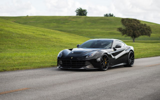 Black sports car green hillside - side profile free wallpaper