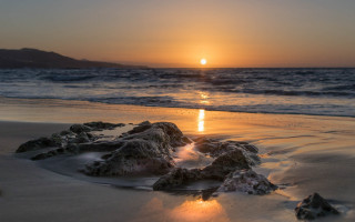 Sunset ocean rocks beach mountain - a mountain in the distance free wallpaper
