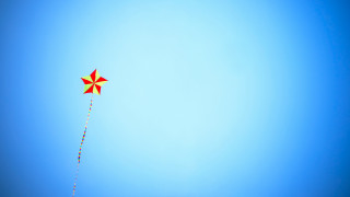 Red yellow kite flying blue - a blue sky background free wallpaper