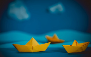 Yellow paper boat blue surface - a blue surface free wallpaper