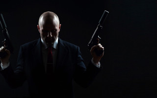 Man in suit holding guns - his hand free wallpaper for desktop