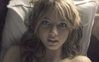 Blue eyed woman laying in - a white sheet free wallpaper