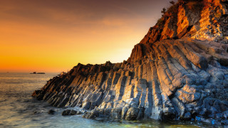 Rock formation ocean boat sunset - a boat in the distance free wallpaper