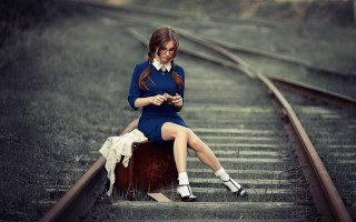 Woman sitting suitcase train track - her phone free wallpaper