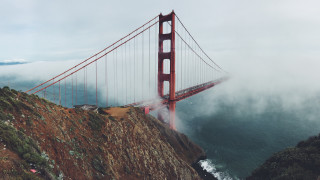 Large bridge foggy water cliff - a large bridge over a body of water free wallpaper