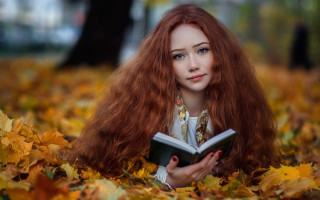 Red haired woman leaves reading - a tree in the background free wallpaper