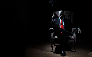 Man suit smoking dark room - vanita free wallpaper