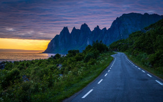 Mountain road water sunset landscape - a mountain in the background and a body of water free wallpaper