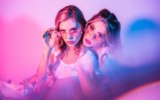 Two girls glasses mirror retrowave - background behind them free wallpaper