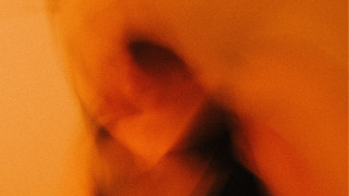 Blurry person black shirt yellow - a white wall free wallpaper