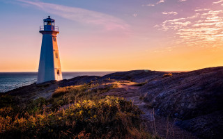 Lighthouse rockycliff ocean sunset pinksky - a rocky cliff free wallpaper