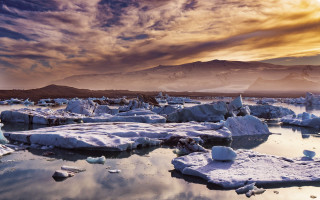 Ice mountains lake sunset shore - top of a lake under a cloudy sky free wallpaper