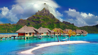 Tropical island dock thatched huts - a tropical island free wallpaper