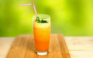 Orange juice glass straw wooden - a blurry background of trees and grass free wallpaper