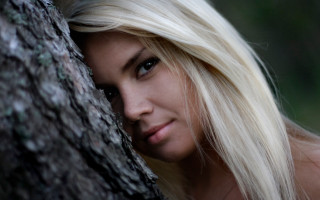 Blonde woman leaning against tree - leaning free wallpaper
