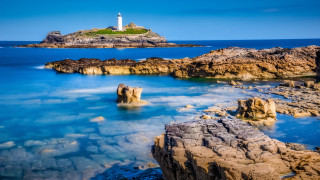 Lighthouse rocky shore blue water - a rocky shore free wallpaper