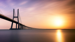 Large bridge sunset water sky - over a body of water free wallpaper