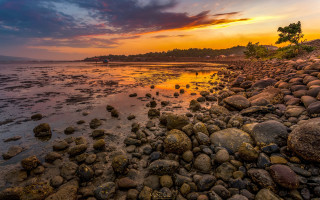 Sunset rocky beach dusk cityscape - a sunset over a rocky beach free wallpaper