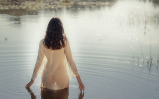 Woman lake hands in water - her back free wallpaper