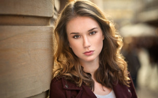 Woman portrait serious browneyes redjacket - a woman leaning against a wall free wallpaper