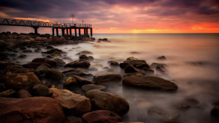 Pier sunset ocean rocks mountain - rich moody colour free wallpaper