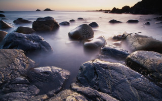Rocky beach sunset clouds ocean 3 - the water and a sunset in the background free wallpaper