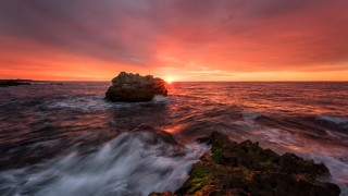 Mystical rock island sunset ocean - a red sky above free wallpaper