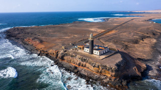 Lighthouse rocky island ocean waves 2 - aerial free wallpaper