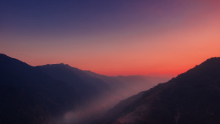 Mountain range sunset foggy valley - a view of a mountain range free wallpaper